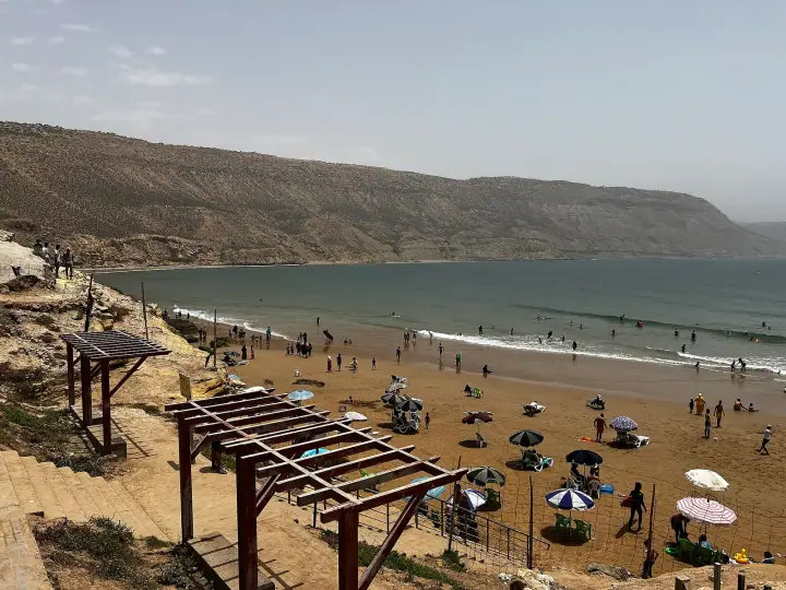 Paillotes et parasols sur la baie d’Imsouane, au pied des falaises